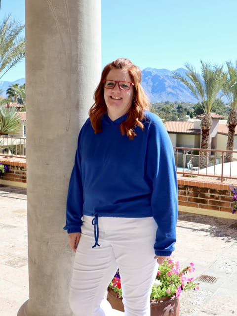Meghan, a patient who screened with Cologuard, standing outdoors with mountains in the background
